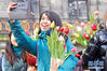 　1月18日，在荷兰阿姆斯特丹，一名参与者在水坝广场捧着郁金香自拍。 当日，荷兰迎来一年一度的国家郁金香日。 新华社发（西尔维娅·莱德雷尔摄）
