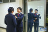 1月18日，王丽丽（右）为姐姐王娟娟整理制服。