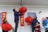 1月21日，在位于安徽滁州的中铁四局滁宁城际铁路一期工程项目部驻地，蒋皓（左二）在挂灯笼迎接春节，他的父亲蒋高建（左三）、母亲周美英（左一）、妻子柯菁兰（右一）和儿女在一旁。新华社记者 张端 摄