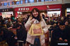 Wu Mengfan, a university sophomore from East China's Anhui province, poses for photos with pastries as gifts for her parents at the Beijing Railway Station in Beijing, capital of China, Jan 14, 2020. 