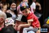 1月25日，在菲律宾首都马尼拉，一名身着中国传统服饰的男孩骑在大人的肩头，参加庆新春活动。 为了迎接1月25日的中国农历鼠年新春，全世界不同地区的人们举行了形式多样的庆祝活动。 新华社发（乌马利摄）