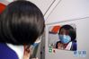 1月23日，在沈阳桃仙机场，陈玲在飞机上戴上口罩，准备开始工作。新华社记者 杨青 摄