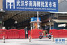 1月29日，市民经过已经被封闭的武汉华南海鲜批发市场。 新华社记者 熊琦 摄