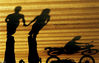 2006年，长沙市潇湘大道，牵手的人在落日里走过斑马线。一对恋人手牵手过马路，旁边一市民骑摩托车开过，倒影别样有味道。
