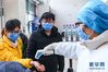 2月13日，庞振（中）和陈美茹（左）在进入北京地坛医院时接受体温测量。据介绍，重症医学科平时就非常忙碌，今年这个春节更是如此。新华社记者 张玉薇 摄