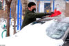 2020年2月15日，辽宁沈阳，一车主在清扫车上的积雪。