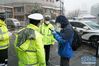 2月15日，新华社记者李思远（右一）在武汉市硚口区利济路附近采访交警。 新华社发