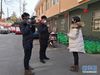 2月9日，新华社记者方亚东（左）、冯国栋（中）在武汉市武昌区大东门社区采访社区工作人员。新华社发