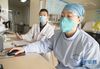 2月22日，武汉市汉口医院呼吸科医生杨丽（右）在办公室查看病历。她在新冠肺炎治愈后于2月21日开始正式返岗上班。新华社记者 才扬 摄