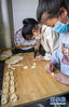 拉萨市儿童福利院的孩子旦增拉姆（左）和同伴制作藏族传统食品“卡赛”（2月22日摄）。新华社记者 孙非 摄