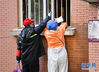 2月23日，武汉市武昌区华锦社区的志愿者从窗口为一名行动不便的老人递爱心菜。 新华社记者 程敏 摄