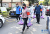 2月23日，武汉市武昌区华锦社区的志愿者为社区居民送菜上门。新华社记者 程敏 摄