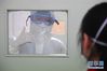 易俊丰（左）在湖南省人民医院发热门诊为留观人员加油打气（2月7日摄）。  新华社记者 陈泽国 摄