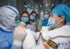 2月8日，在武汉雷神山医院，护士在观看示范防护服的穿戴。新华社记者 肖艺九 摄