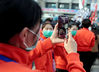 A medical worker livestreams the ceremony to her son. ZHANG ZHENG/FOR CHINA DAILY