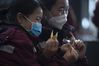 Medic Li Jian (L) and her teammate from southwest China's Guizhou Province make paper crane while waiting for a train at the Wuhan Railway Station in central China's Hubei Province, March 17, 2020. Some medical assistance teams started leaving Hubei Province on Tuesday as the epidemic outbreak in the hard-hit province has been subdued. (Xinhua/Fei Maohua) 