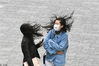 2020年3月18日，北京大风已进城，下班时间，风力达八九级以上，走在街头的男男女女，头发被吹乱，随风飘逸。罗恒/IC photo

