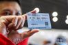3月25日，一名队员在北京西站展示车票。 新华社记者 张玉薇 摄