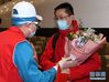 3月25日，接站的工作人员为援鄂国家医疗队队员送上鲜花。新华社记者 张晨霖 摄