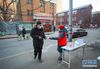 2月7日，沈阳市和平区太原街街道沈阳站社区志愿者将防疫宣传单发给居民。  新华社记者 龙雷 摄