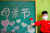 A boy holds a flower for his mother at a kindergarten in Rugao city, Jiangsu province, May 8, 2020. [Photo/Sipa] 