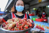 A staff member of a brasserie shows cooked crayfish at a food court in Jinhu County, east China's Jiangsu Province, May 12, 2020. Jinhu County, located in east China's Jiangsu Province and surrounded by Baima Lake, Baoying Lake and Gaoyou Lake, boasts favorable conditions to develop aquaculture. (Xinhua/Ji Chunpeng)