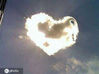 2012年10月13日，一朵心形白云飘过天空遮住太阳，云朵与阳光交相辉映，金光四射。IC photo 