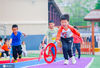 2020年5月26日，在江苏省如皋市吴窑幼儿园操场上，小朋友在参加民间游戏“滚铁环”竞赛。
