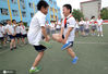 2014年5月28日，河北省邯郸市渚河路小学开展“寻找父母儿时的老游戏”迎六一活动，感受70后、80后的童年。同学们在玩弹拐拐。郝群英/IC photo
