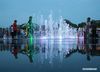 Children splash around in a musical fountain at a leisure square in Yangzhou, east China's Jiangsu Province, June 27, 2020. (Photo by Meng Delong/Xinhua)