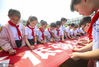 2020年7月1日，江苏淮安，小学生在横幅上签名。