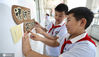 2020年7月1日，江苏淮安，小学生张贴节约提示语。