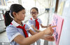 2020年7月1日，江苏淮安，小学生张贴节约提示语。