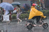 2020年7月11日上午10时30分左右，南京街头大暴雨倾盆而下，出行的市民顶雨小心前行，车辆开灯缓行。
