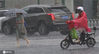 2020年7月11日上午10时30分左右，南京街头大暴雨倾盆而下，出行的市民顶雨小心前行，车辆开灯缓行。