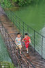 2020年7月13日，江苏省宿迁市泗洪县洪泽湖湿地景区游人如织。两位小朋友在水面吊桥玩耍。
