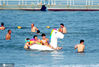 7月14日，人们在山东蓬莱市海上嬉戏，体验戏水乐趣，感受清凉夏日。 于良意/IC photo
