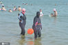 2020年7月16日，在青岛市第一海水浴场，两名穿戴“脸基尼”防晒面罩的女泳客准备下海纳凉。王海滨/IC photo
