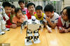 2020年7月21日，在江苏省镇江市风车山社区，江苏大学志愿者在指导小朋友进行机器人操作。