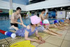 2020年7月24日，暑假期间，江苏省连云港市体育中心的游泳场馆专门聘请了专业教练、救生员，开展暑期游泳培训班，吸引了众多中小学生前来参加学习游泳，以强化自护自救能力，提高其身体素质，从而愉快度过一个快乐的暑假。图为一群学生正在游泳教练的指导下学习游泳技巧。来源：IC photo 王春/IC photo
