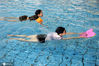2020年7月24日，江苏连云港市体育中心游泳馆内，一群学生正在游泳教练的指导下学习游泳技巧。