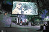 2020年7月28日晩，四川省华蓥市红岩乡茶园村的群众在树荫下一边纳凉一边观看故事片“杀出重围”。