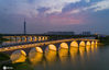 2020年7月30日，江苏省淮安市，市民在双九孔桥上欣赏里运河的美丽夜色。近年来，淮安市采取生态、文化、旅游相结合的建设模式，打造开放式、低密度的里运河文化长廊旅游区取得成效。如今的里运河沿岸水绿相映、人景相称，处处风景独好。
