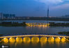 2020年7月30日，江苏省淮安市，市民在双九孔桥上欣赏里运河的美丽夜色。近年来，淮安市采取生态、文化、旅游相结合的建设模式，打造开放式、低密度的里运河文化长廊旅游区取得成效。如今的里运河沿岸水绿相映、人景相称，处处风景独好。

