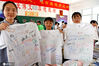 2020年7月4日，安徽淮南二中高三学生在文化衫上为同学写下祝福的话语，分享毕业喜悦。陈彬/IC photo