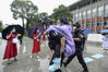 A police on duty carries a student about to take the gaokao with pain in her leg into a test site in Wuhan, Central China's Hubei province, amid rain on July 7, 2020. [Photo by Wang Jiang/provided to chinadaily.com.cn]