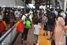 2020年8月12日，高铁长沙南站，旅客携带着行李进站上车。进入8月以来，随着各地集中休假及旅游出行需求等因素影响，铁路“暑运”迎来一波小高峰，其中有许多“小候鸟”跟随家长奔波在旅途中。