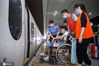 2020年8月1日，在南京南站“158”雷锋服务站，一名大学生志愿者在为旅客指路。今年暑假期间，铁路南京站、南京南站首次面向社会以家庭、个人、志愿服务小组为单位公开招募志愿者，吸引了许多大、中学生以及学生家长报名参加，他们身穿橙色马甲，热心帮助旅客解决各种问题，在志愿服务中丰富暑期生活。