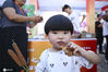 2020年8月1日，江苏淮安，一名小朋友品尝红薯。