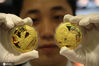 2012年9月12日，在郑州市二七路金鑫珠宝城，营业员展示一款用黄金打造的月饼“金龙银月”。 杨正华/IC photo

